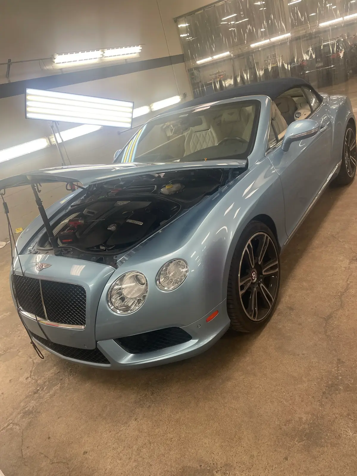 The Hail Solutions Olathe shop interior with a vehicle in the bay and professional PDR equipment