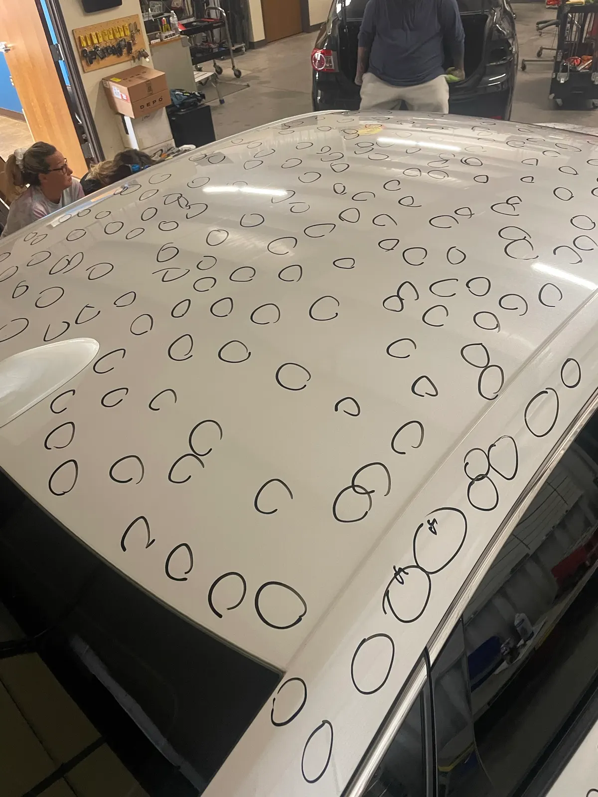 Severe hail damage on a vehicle roof showing heavy dent concentration