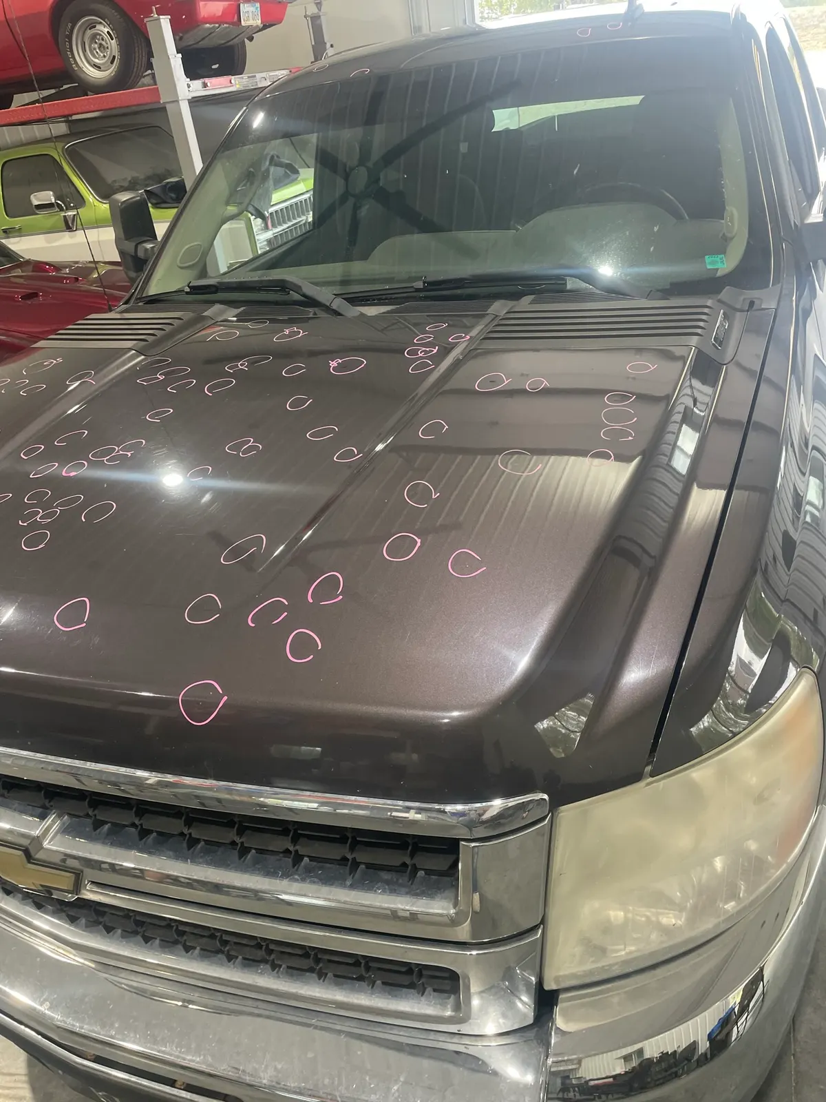 Light hail dents revealed under LED line-board inspection on a vehicle hood