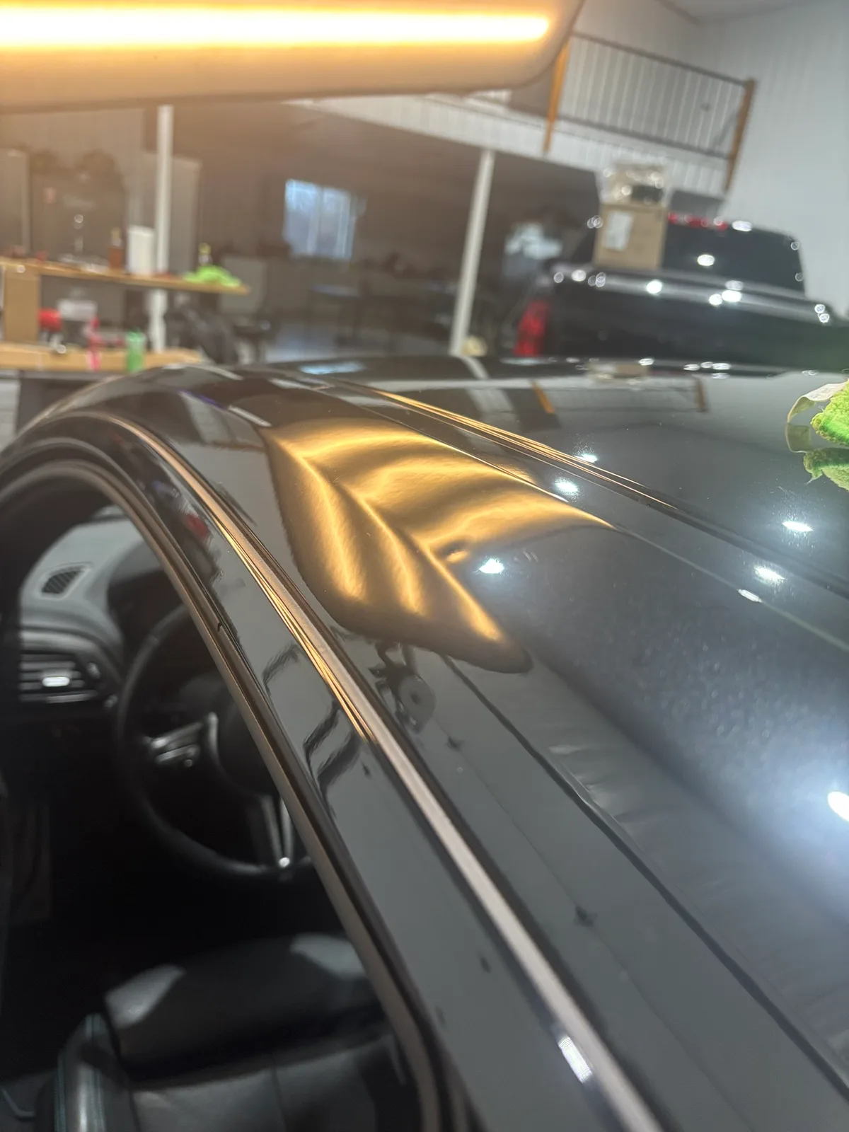 Vehicle trunk lid revealing hail dents under LED line-board inspection