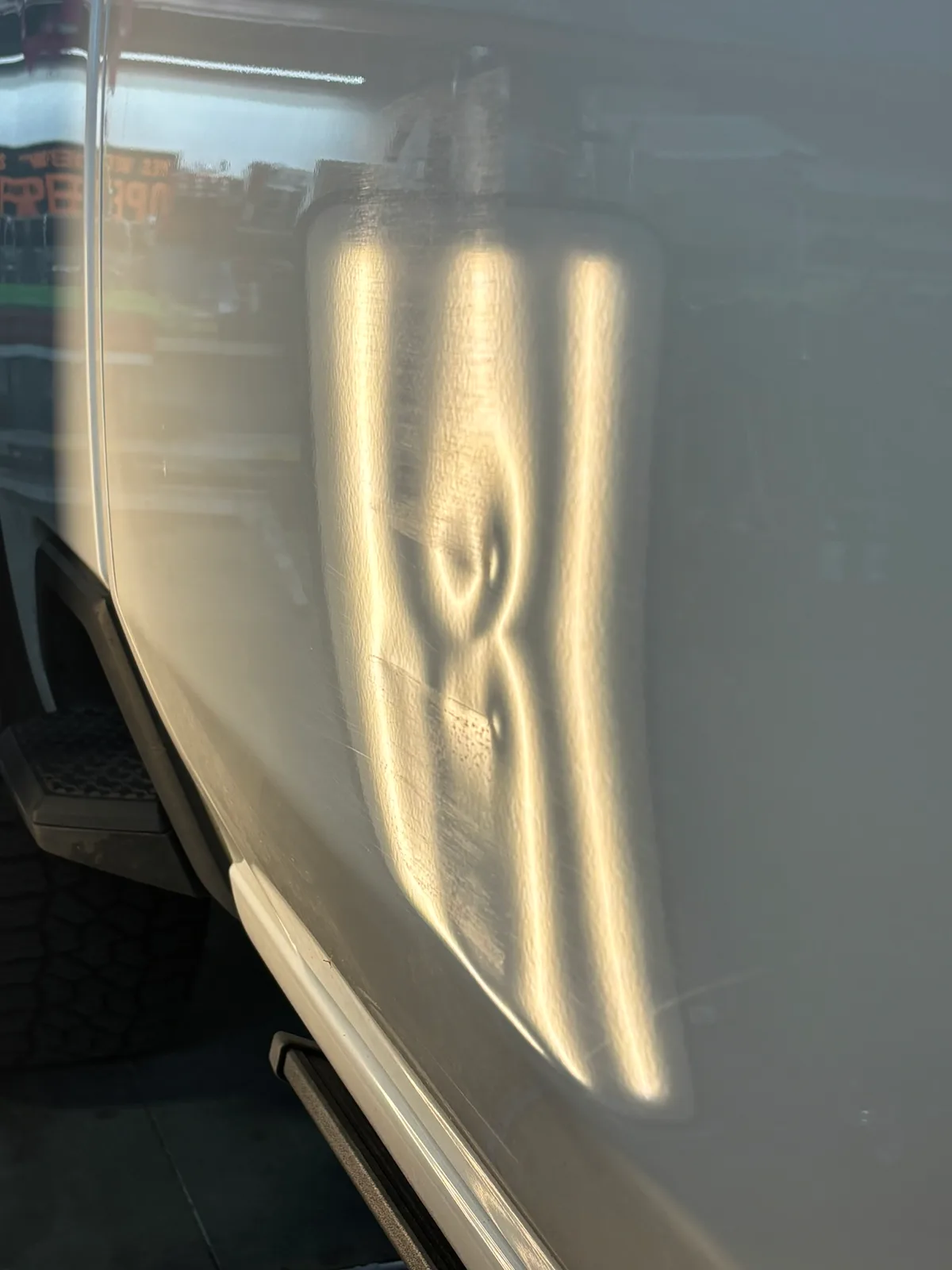 A large hail dent revealed by LED line-board inspection on a customer vehicle at the Hail Solutions shop